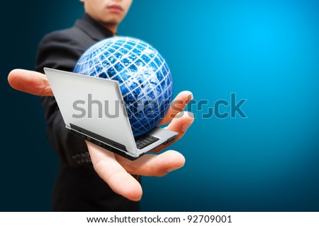 Business man hold notebook computer and globe on