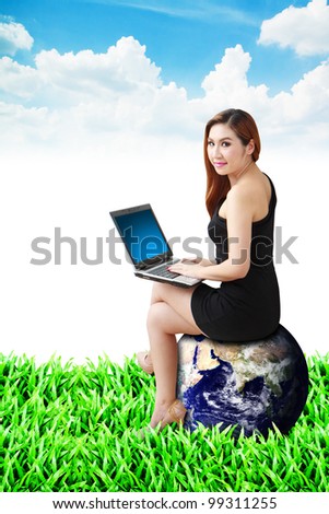 Lady on globe use notebook computer on the grass field : Elements of this image furnished by NASA