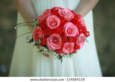 delicate red rose wedding bouquet of roses in the hands of the bride