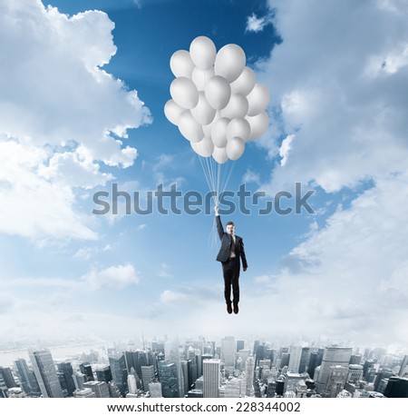 Businessman flying on balloons