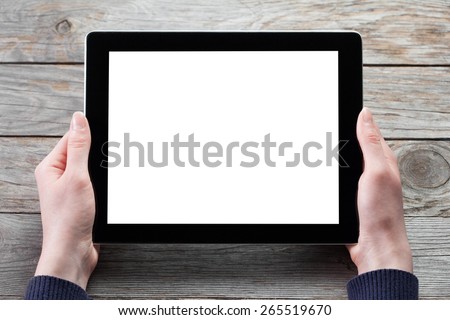 female hands holding digital tablet computer with isolated screen over old grey wooden background table
