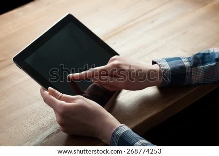 woman shows screen of digital tablet in his hands.