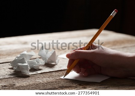 woman writing on sheet of paper