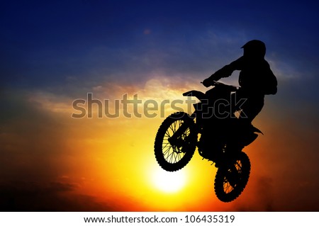 Silhouette of a motorcyclist on a background of dark sky