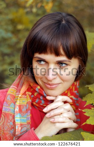 Portrait of the beautiful young happy woman in the autumn wood
