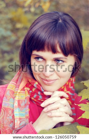 Portrait of the beautiful young happy woman in the autumn wood