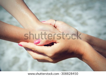 Hands mother and baby close up on a background of the sea