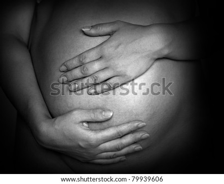 Pregnant mother to be holding her belly.