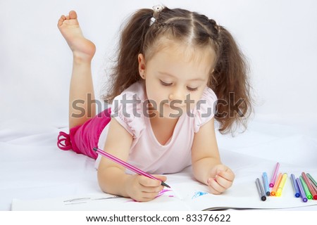 little pretty girl draws with markers on a white background isolated