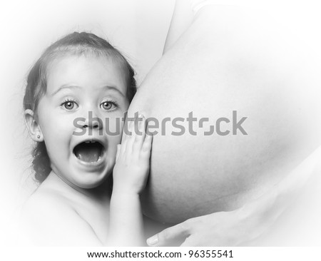 black and white portrait of a little surprised girl and a pregnant belly mom