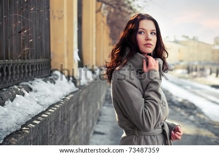 Young woman stands alone on the street