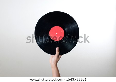 Similar – Image, Stock Photo Man holding vinyl record. Vintage music style. Rock style. Male wearing black jacket holding black disc standing on dark background. Retro music