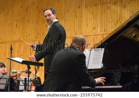DNIPROPETROVSK, UKRAINE -?? FEB. 23: Pianist Vyacheslav Poprugin and Youth Symphony Orchestra FESTIVAL- conductor Dmitry Logvin perform at the Conservatory on Feb. 23, 2015 in Dnipropetrovsk, Ukraine