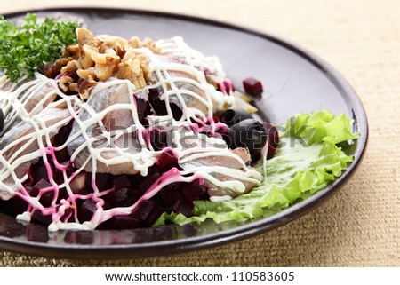 salad with fish and nuts in black dish