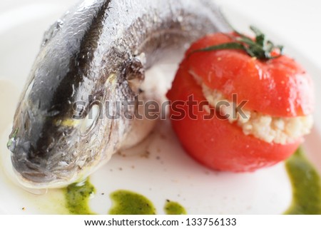 tasty boiled big fish with tomato on white dish