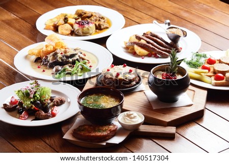 a lot of dishes with different food on wooden background