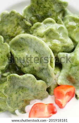 white dish with basil and spinach ravioli