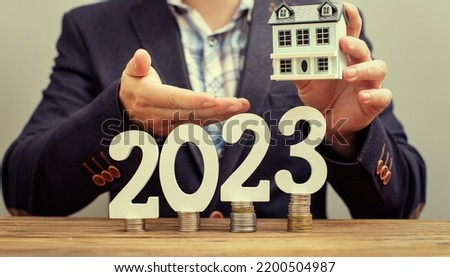 analyzes real estate profitability with augmented reality digital graphics, positive performance in 2023, businessman calculates financial data for long term investment. Stock fotó © 