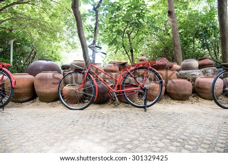 classic bike stand in the garden which decorate with earthen jar