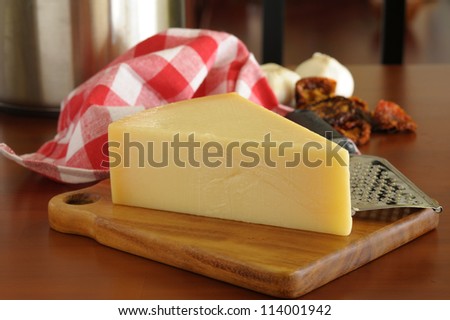 Parmesan cheese and other Italian ingredients photographed on a wooden table.