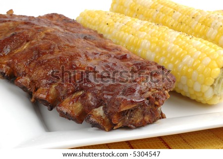 Rack of delicious ribs with corn on the cob.