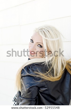 woman in black leather jacket and bleach blonde hair looking over shoulder