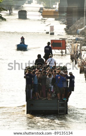 BANGKOK, THAILAND - NOVEMBER 19 -Thai residents are back home transported on a military truck through a flooded street in the afternoon of Saturday November 19, 2011 in Bangkok, Thailand