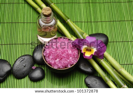Bamboo grove and salt in bowl with orchid with massage oil on mat