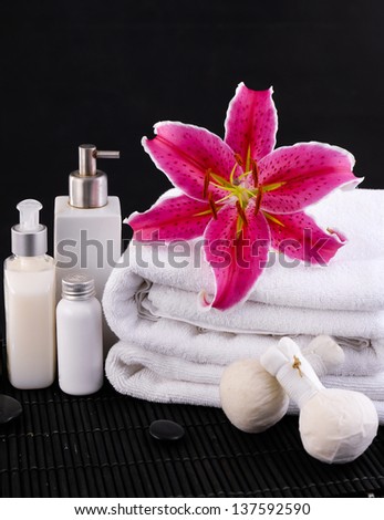 spa composition of towel, candles and Ginger flower, massage oil