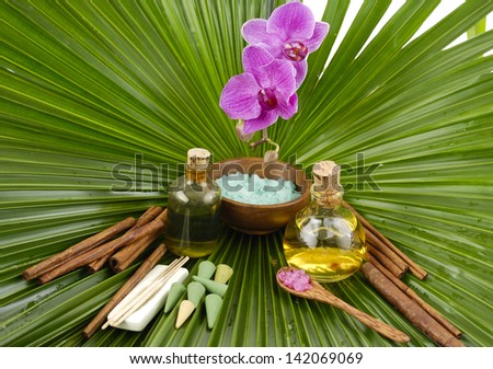 Spa set with, spa oil , salt in bowl, ,orchid on wet palm leaf