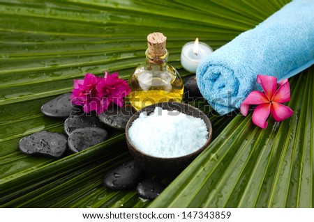 spa supplies with frangipani. Sat in bowl, massage oil, wet palm