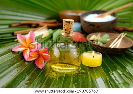 Spa set with frangipani,spa oil ,towel salt in bowl ,candle on wet palm leaf