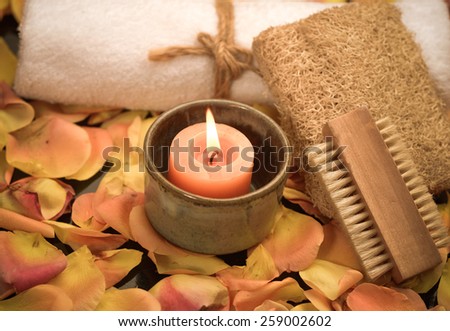 Bath spa with rose petals with candle in bowl ,towel