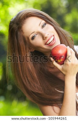 portrait  long-haired woman hands red  apple background summer park