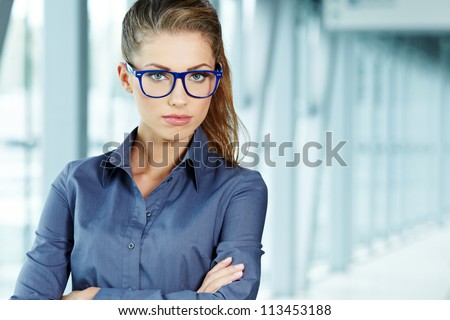 Portrait of a cute young business woman smiling, in an office environment
