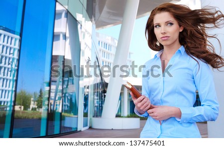 young businesswoman standing in front of office buildings