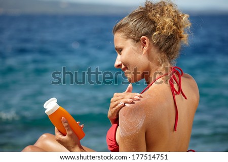 woman applying sun protection lotion