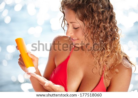 Sunscreen beach woman in bikini applying sun block solar cream for UV protection.