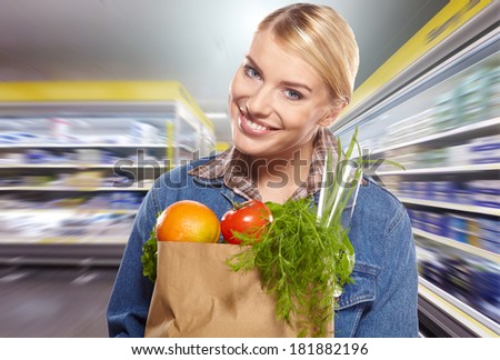 woman shopping for fruits and vegetables in produce department of a grocery store/supermarket