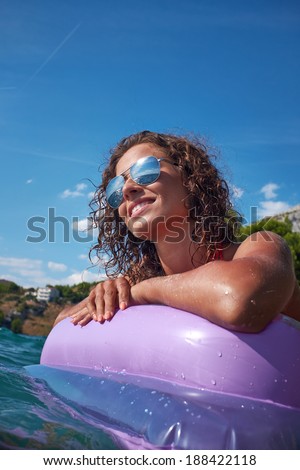 Woman relaxing on inflatable mattress.
