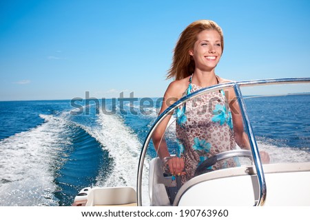 Summer vacation - young girl driving a motor boat