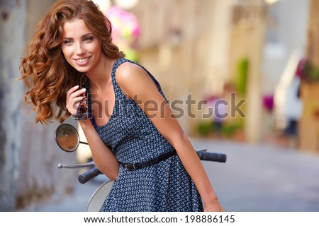 beautiful italian woman sitting on a italian scooter.