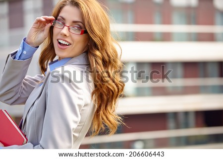 Young businesswoman (real estate agent) presenting detached modern houses