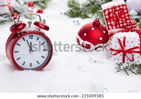 Red vintage alarm clock in the snow