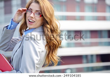Young businesswoman (real estate agent) presenting detached modern houses