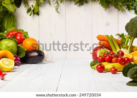 frame with fresh organic vegetables and fruits on wooden background