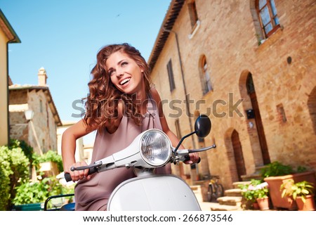 Young beautiful italian woman sitting on a italian scooter.