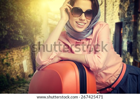 Woman with suitcase on the street of a small Italian town