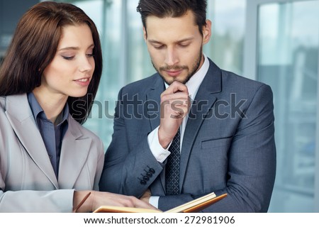 Young Business couple looking at file indoors.