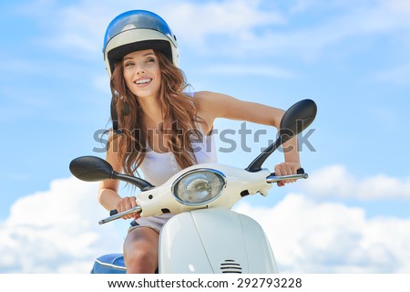 Attractive happy woman on a scooter